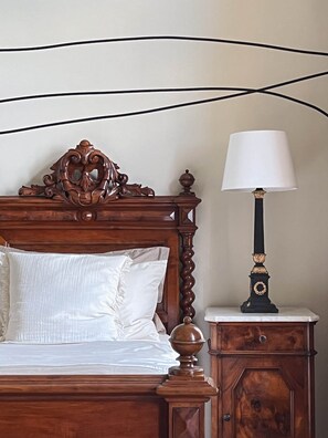A bed with a wooden headboard, a bedside lamp, and a nightstand.