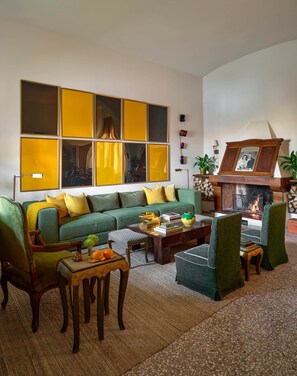 Una sala de estar con un sofá verde, una mesa de centro y una chimenea.