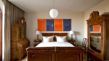 Una camera da letto tradizionale con un letto di legno, due comodini, uno specchio grande e un quadro appeso al muro.