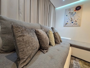 A modern living room with a grey sofa and multiple cushions. - Pedro's Place Battersea (London)