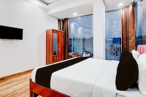 Une chambre d’hôtel moderne dotée d’un grand lit, d’une armoire, d’un téléviseur à écran plat et d’un balcon avec vue.
