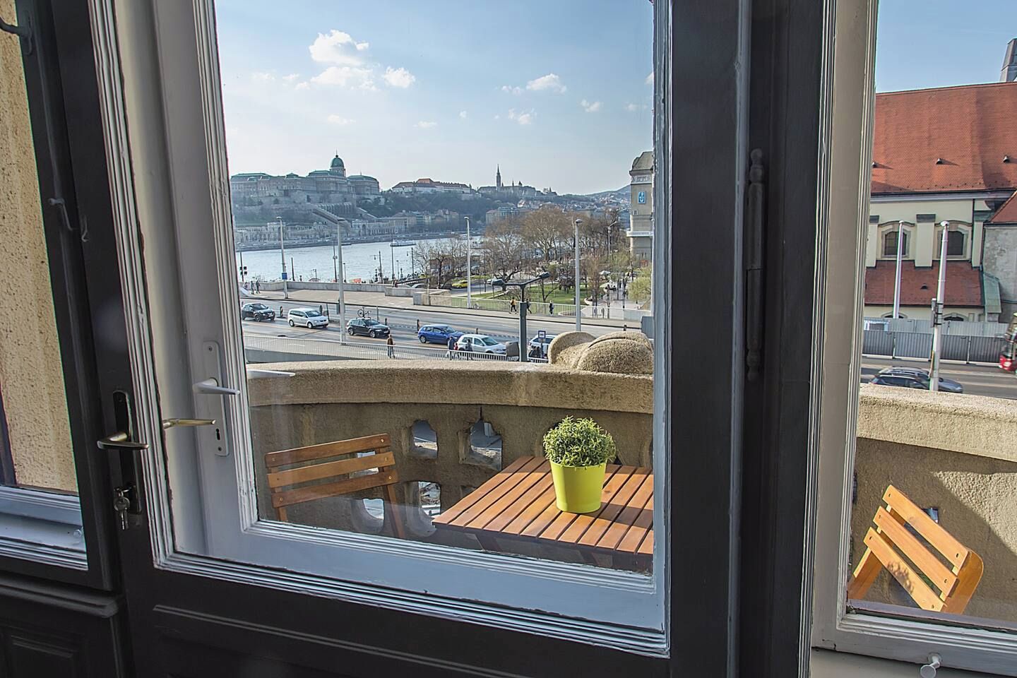 Ein Balkon mit Blick auf eine Stadtlandschaft, darunter eine Brücke und Gebäude.
