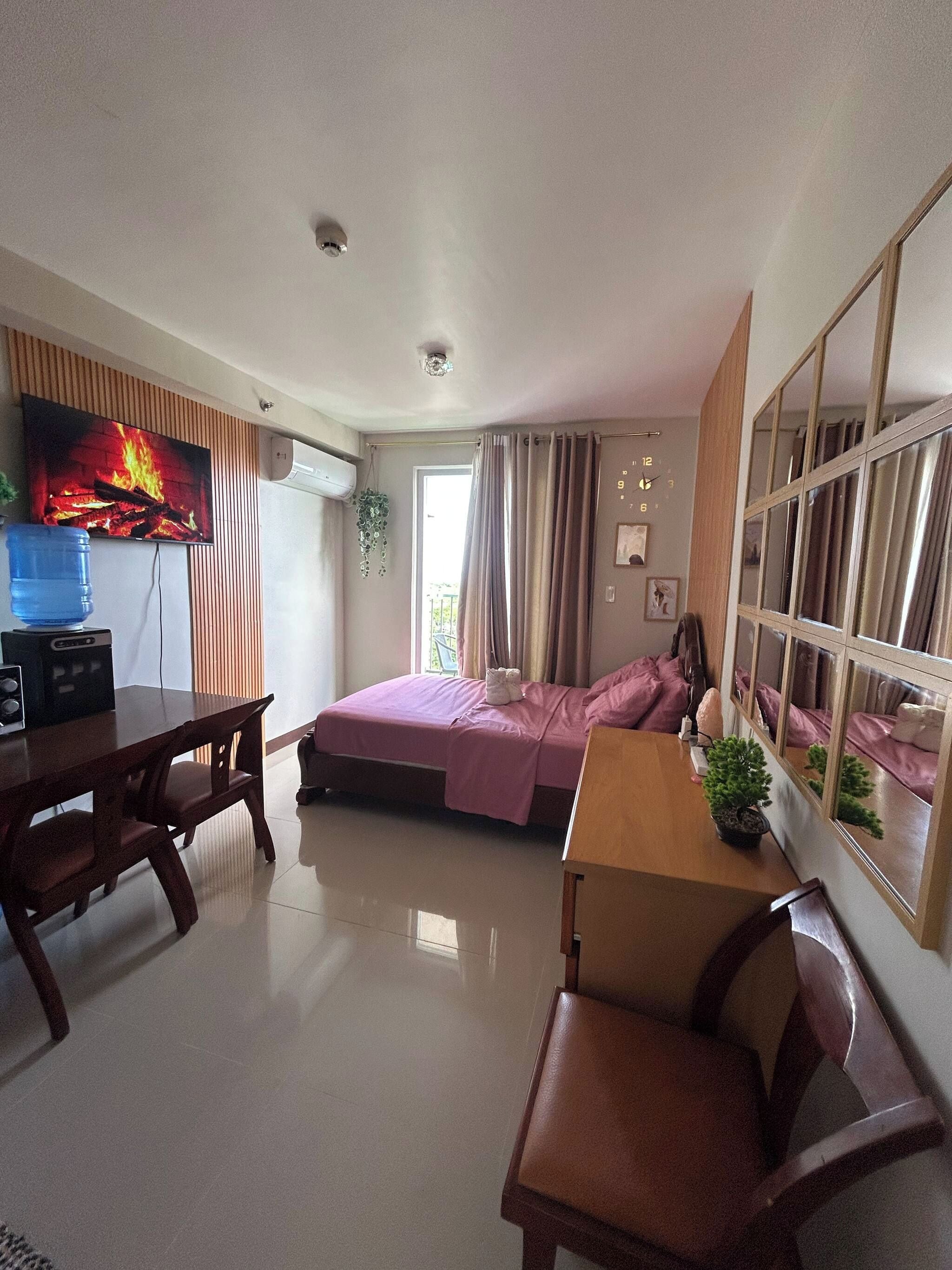 Une chambre d’hôtel avec un lit, un bureau, une chaise, une télévision et une fenêtre.