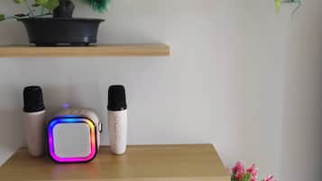 Een plank met een potplant, twee speakers en een afstandsbediening.