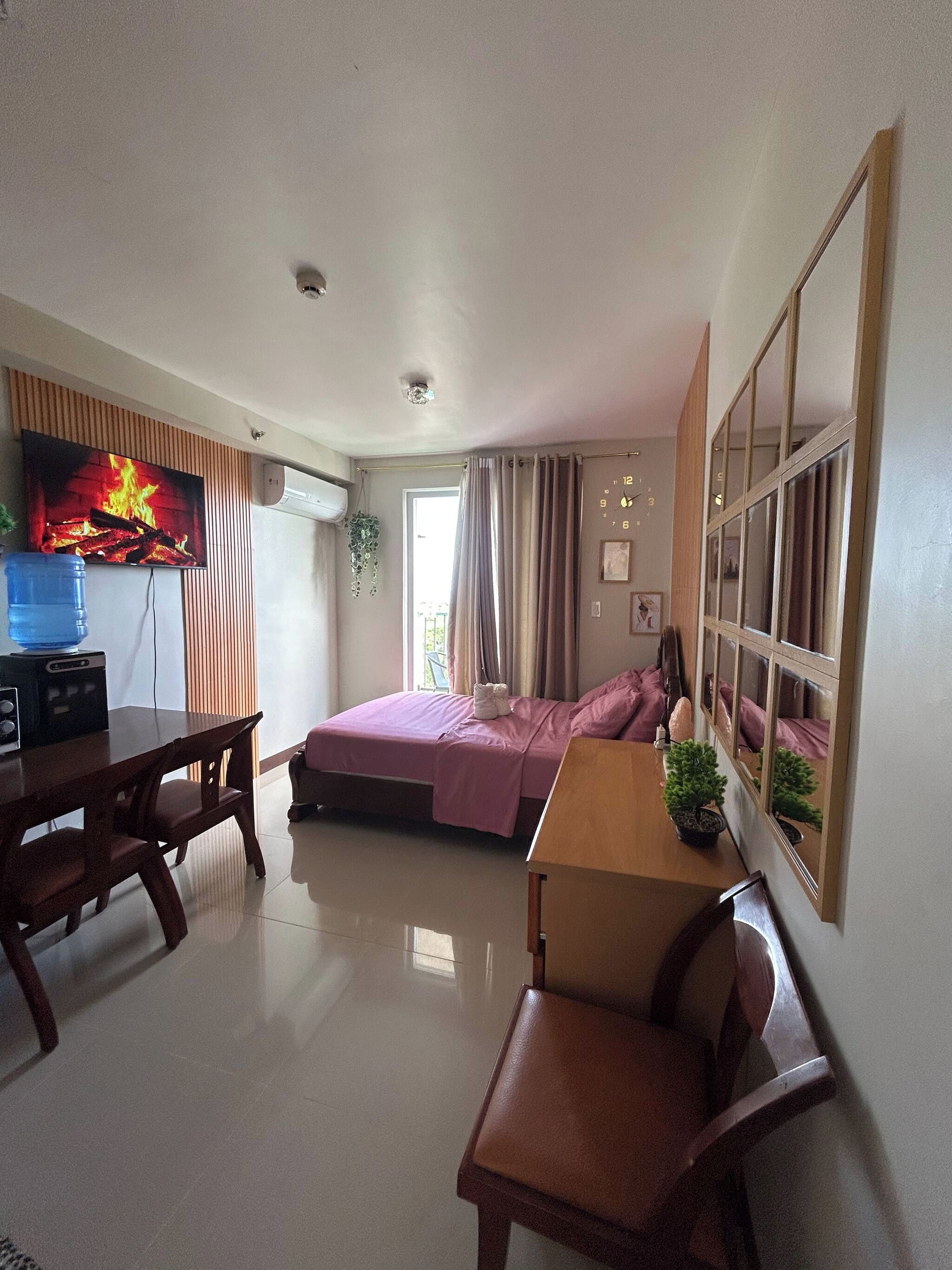 Una habitación con una cama, un escritorio, una silla, un televisor y una ventana.