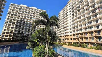 A swimming pool surrounded by high-rise residential buildings with balconies.