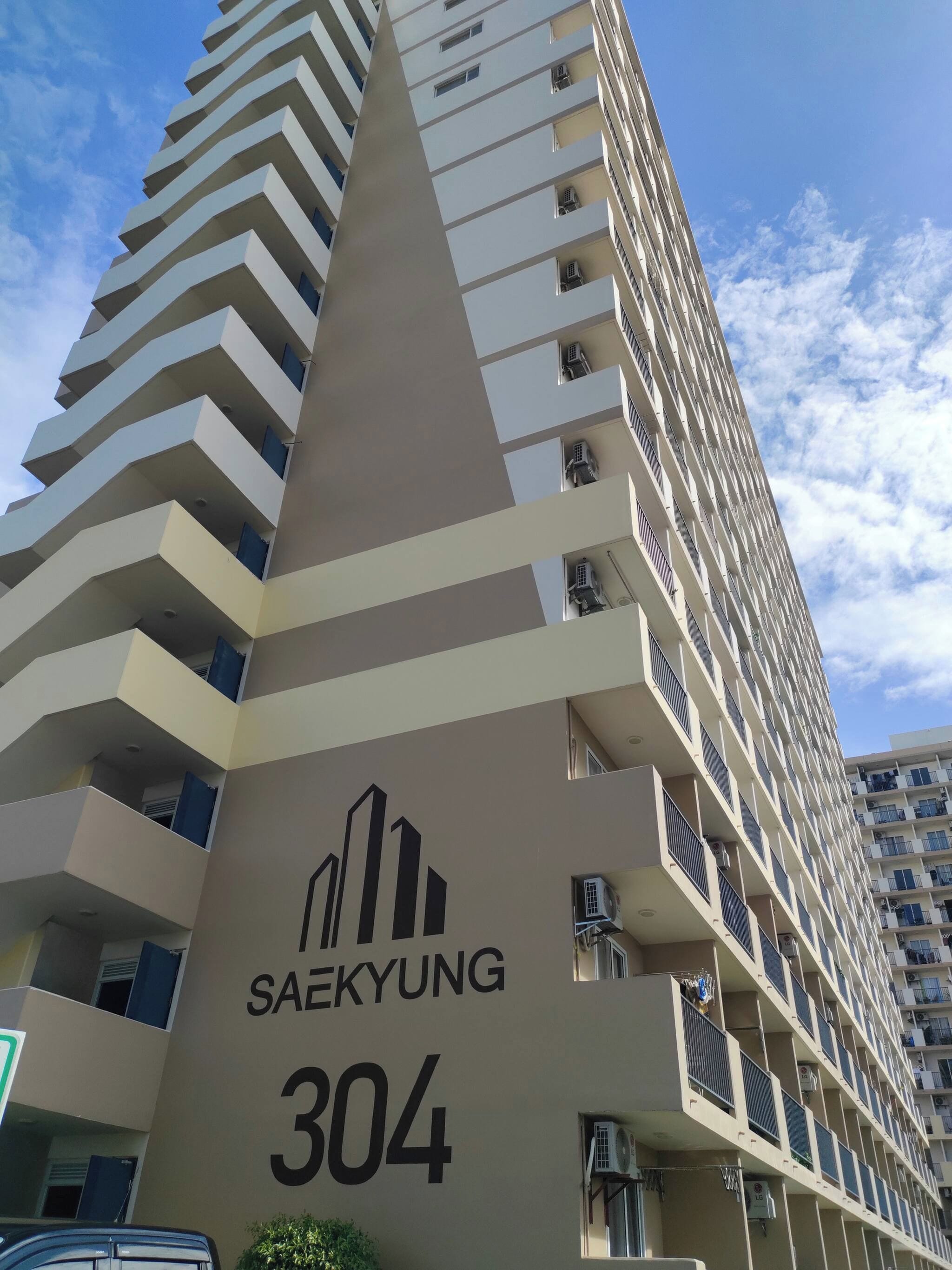Un edificio de gran altura con una fachada distintiva en zigzag, identificado como 'SAEKYUNG 304'.