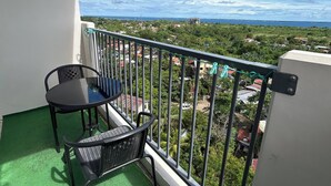 Ein Balkon mit Tisch und Stühlen, Blick auf eine Küstenlandschaft und eine LG Dual Inverter Klimaanlage.