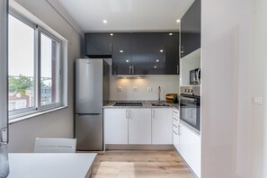 A modern kitchen with a refrigerator, stove, oven, and cabinets. - Nomad's Family - 2-Bedroom Apartment at The Docks in Porto (Porto)