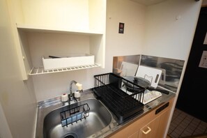 A compact kitchen with a stainless steel sink, a black dish rack, and a white countertop. - goom Monthly Nakasu Maxim (Fukuoka City Chuo-ku Haruyoshi)