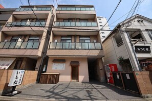 A multi-story building with a ground-level entrance, a small wooden structure in front, and a Coca-Cola vending machine to the right. - goom Monthly Nakasu Maxim (Fukuoka City Chuo-ku Haruyoshi)