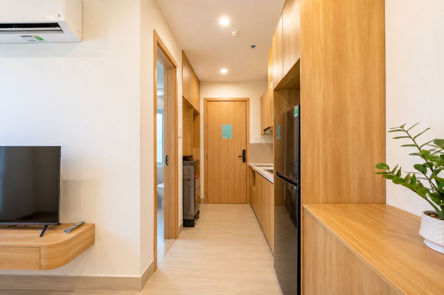 A modern kitchen with wooden cabinets, a built-in refrigerator, and a countertop.