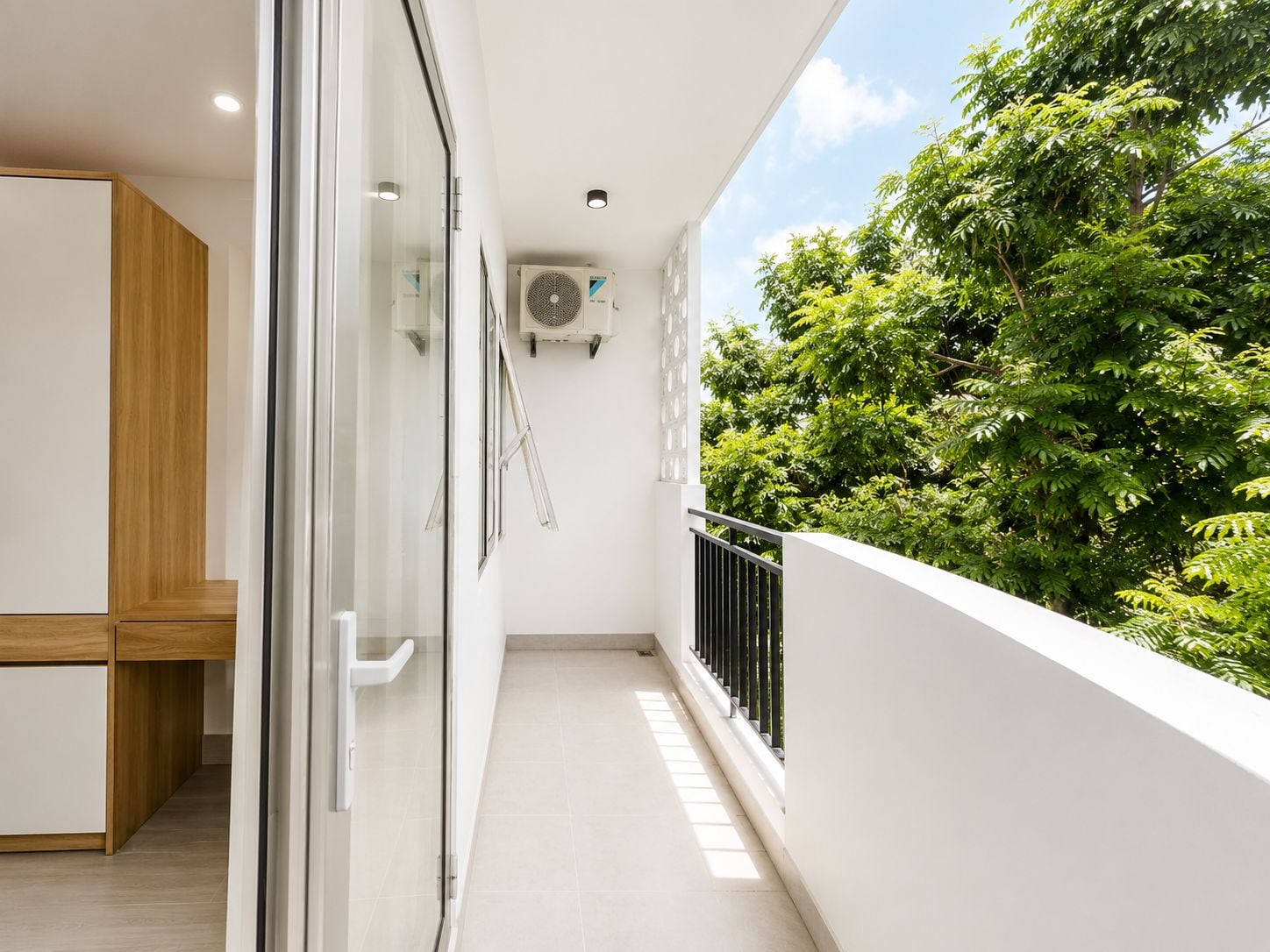 A narrow balcony with a glass door, a white ceiling, and an air conditioning unit.