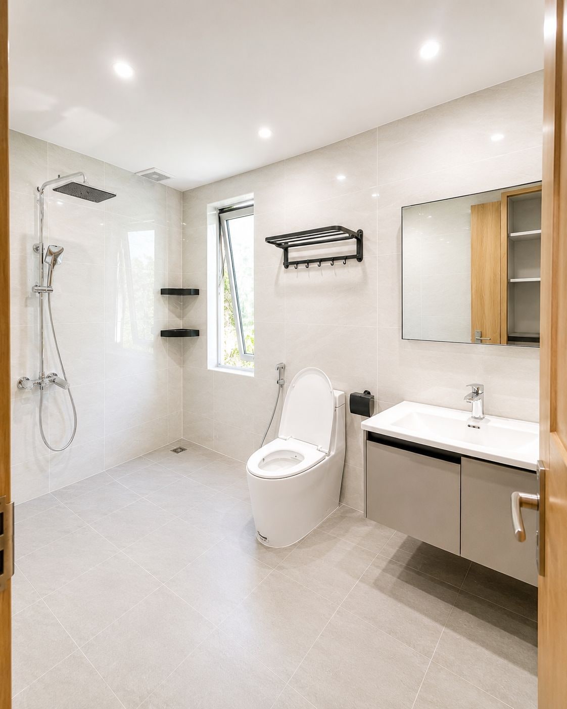 A modern bathroom with a shower, toilet, sink, and a large mirror.