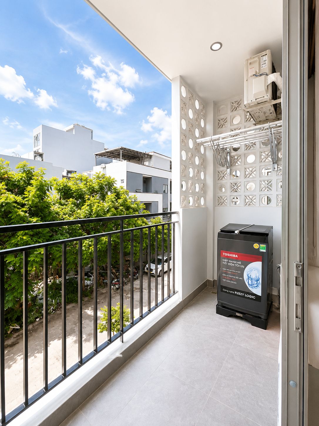 En balkon med udsigt over bybilledet, en salgsautomat og en væg med et mønster.
