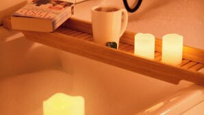Eine Badewanne mit Buch, Tasse und Kerzen.