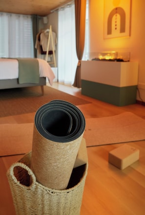 A room with a bed, a desk, and a wall-mounted shelf.