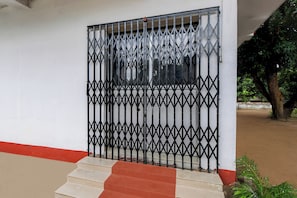 A gated entrance with a metal gate and steps leading up to a building.