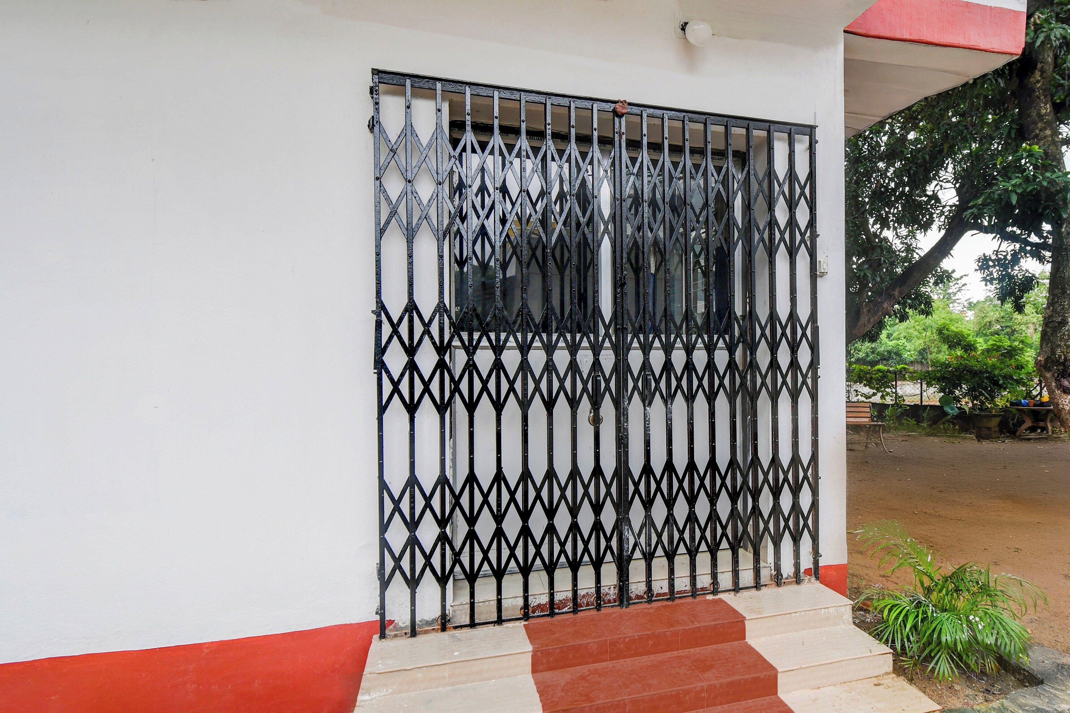 A building entrance with a metal gate and steps leading up to a door.