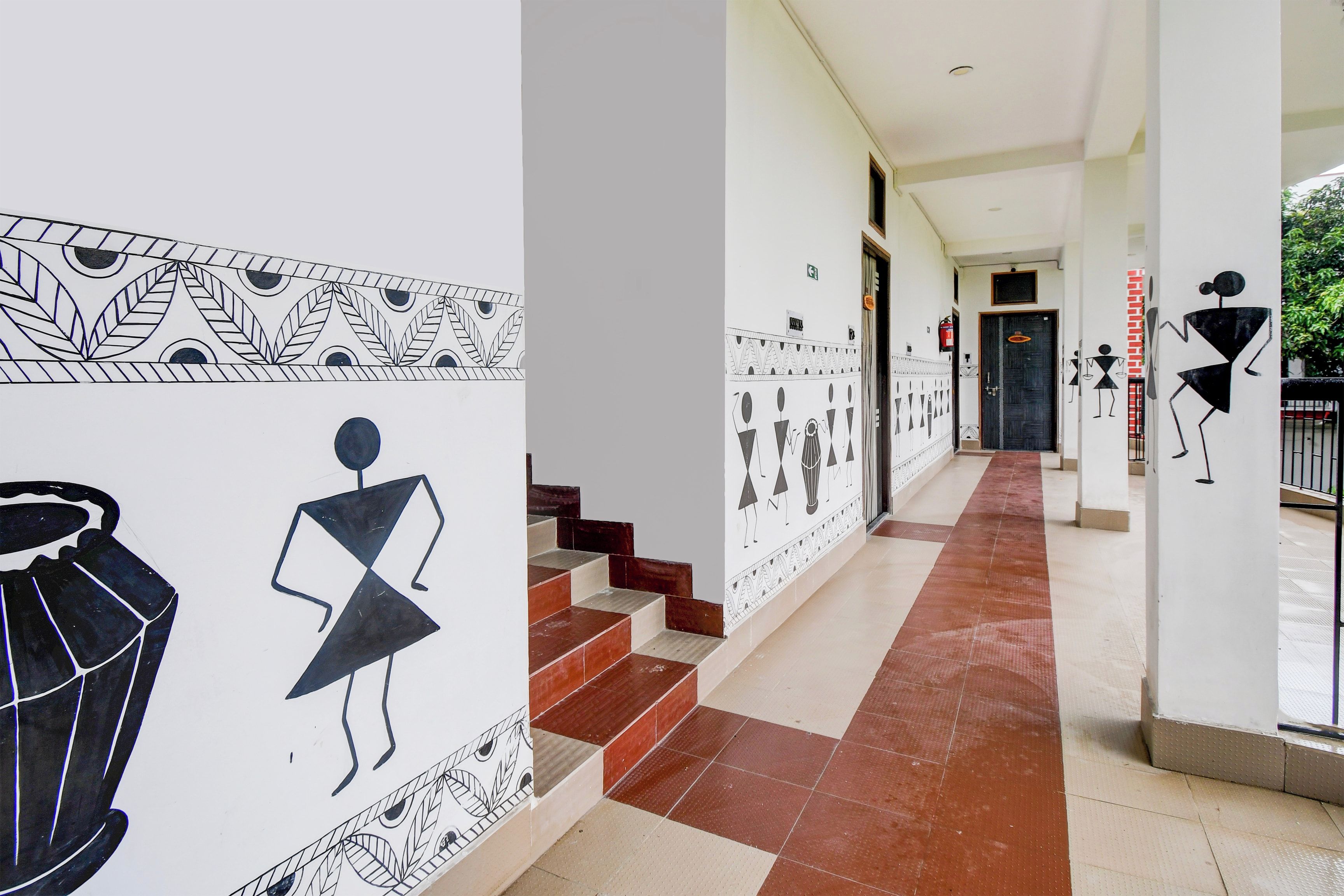 A corridor with patterned walls, a staircase, and a door at the end.