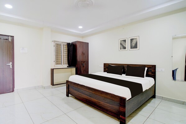 A bedroom with a bed, wardrobe, and a window with a curtain. - Hotel O Ramavarapadu Near PVR Icon (Penumuluru)