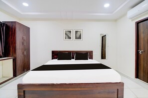 Une chambre à coucher comprenant un lit, une armoire, une porte et deux tableaux accroch és au mur.