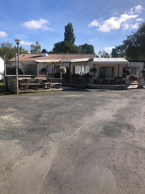 A caravan-style accommodation with outdoor seating and a gravel driveway. - Mobile Home for 2–6 People (Saint-Georges-de-Didonne)
