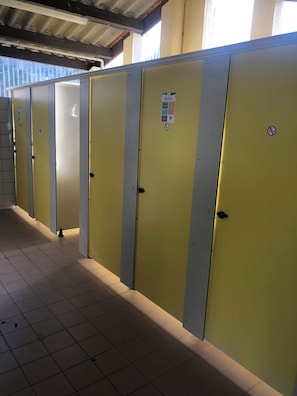 A row of yellow lockers with a tiled floor, a metal roof, and a window in the background. - Mobile Home for 2–6 People (Saint-Georges-de-Didonne)