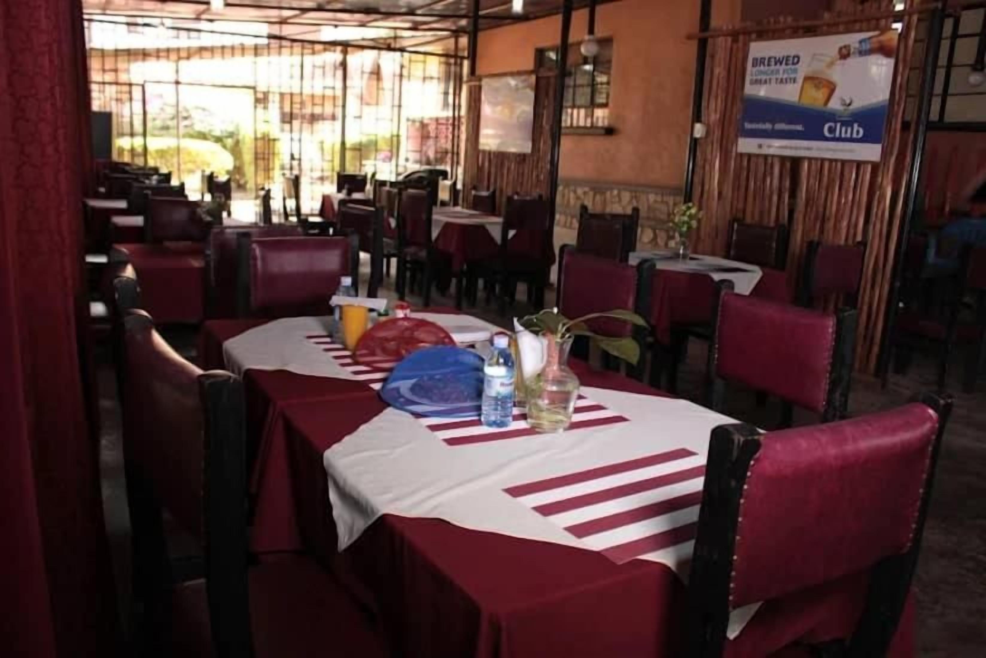 Um restaurante com mesas preparadas para refeições, um banner anunciando um clube e vista para o exterior.