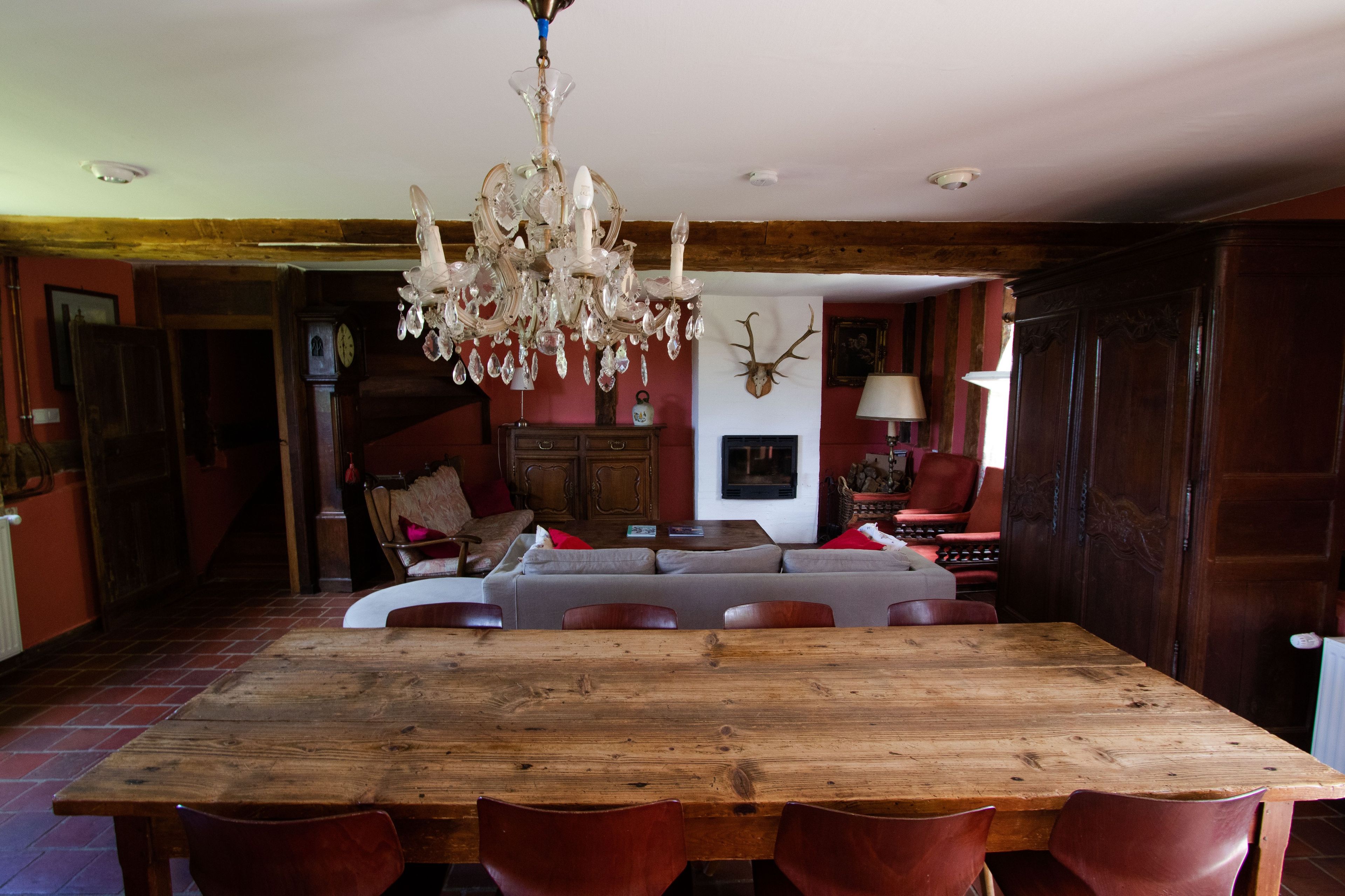 Un'area pranzo con un tavolo e sedie in legno, un lampadario e un camino.