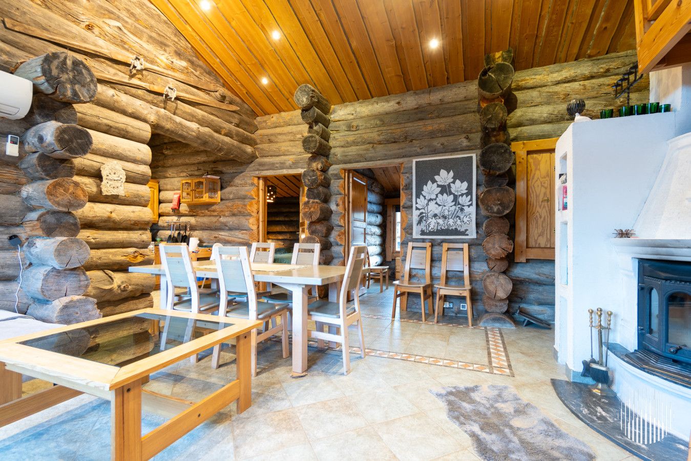 En stuga byggd av timmer med en matplats, en öppen spis och väggar av trä.