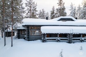 A log cabin surrounded by snow-covered trees.