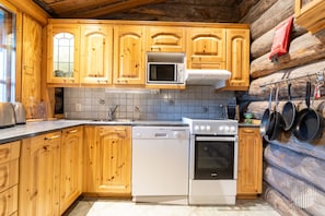 A kitchen with wooden cabinets, a microwave, a stove, and a dishwasher.