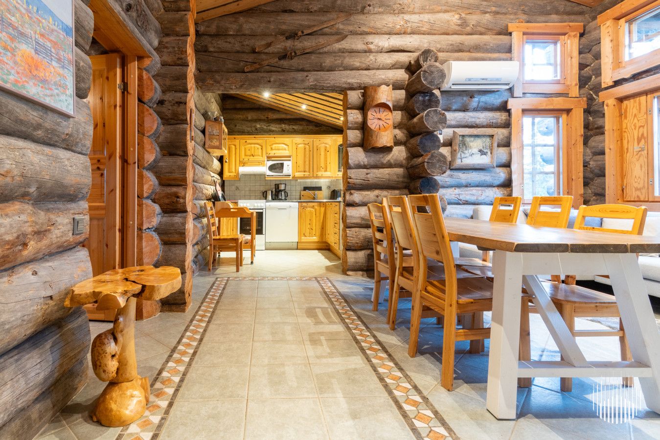 En stuga byggd av timmer med en matplats, ett kök och utsikt över omgivningen.