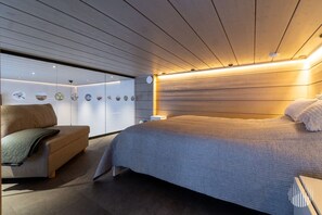 A modern bedroom with a large bed, a sofa, and wall art. - Levi West Slope 1 by Holiday in Lapland (Levi)