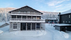A two-story building with a balcony and a sign that reads 'MANDATUM'. - Levi West Slope 1 by Holiday in Lapland (Levi)