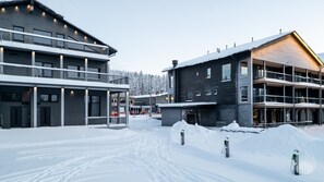 A modern building with multiple floors, a covered outdoor area, and a snowy environment. - Levi West Slope 4 by Holiday in Lapland (Levi)