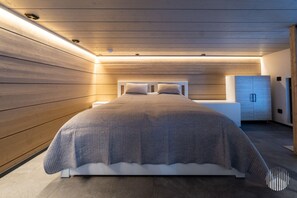 Ein modernes Schlafzimmer mit einem Bett, Nachttischen und einem Kleiderschrank.