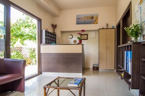 A modern living room with a glass coffee table, a sofa, a wooden cabinet, and a bookshelf. - Holiday Apartment in Paleochora With a Balcony (Kantanos-Selino)