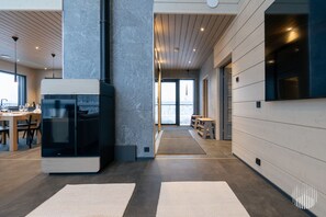 A modern interior with a central column, a black refrigerator, and a seating area with a view. - Levi West Peak View by Holiday in Lapland (Levi)