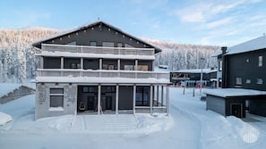A two-story building with a balcony and a sign that reads 'MANDATUM'. - Levi West Slope 3 by Holiday in Lapland (Levi)