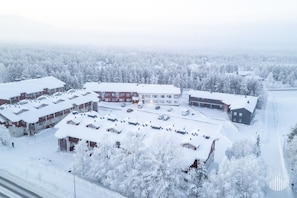 Ein mit Schnee bedeckter Gebäudekomplex mit mehreren Gebäuden, Parkplätzen und einer Straße.
