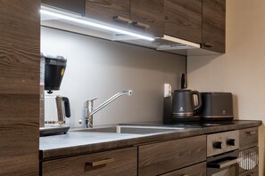A modern kitchen with a built-in coffee maker, a kettle, and a toaster on the counter. - Postintie 3 A 6108 by Holiday in Lapland (Levi)