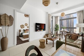 A modern living room with a flat-screen TV, a dining area, and a bedroom with a large window. - Luxe 1BR with Work Desk and Pool in Dubai Marina (Dubai)