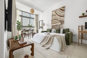 A modern bedroom with a bed, bedside table, and a large woven tapestry. - Luxe 1BR with Work Desk and Pool in Dubai Marina (Dubai)