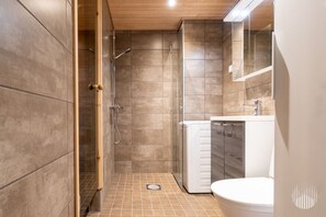 Moderni kylpyhuone, jossa on suihku, wc ja pesuallas.