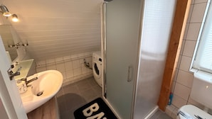 A bathroom with a sink, mirror, shower, and toilet. - Feldblick Rastede Vacation Rental – Covered Patio, Air Conditioning, Dogs Welcome (Rastede)