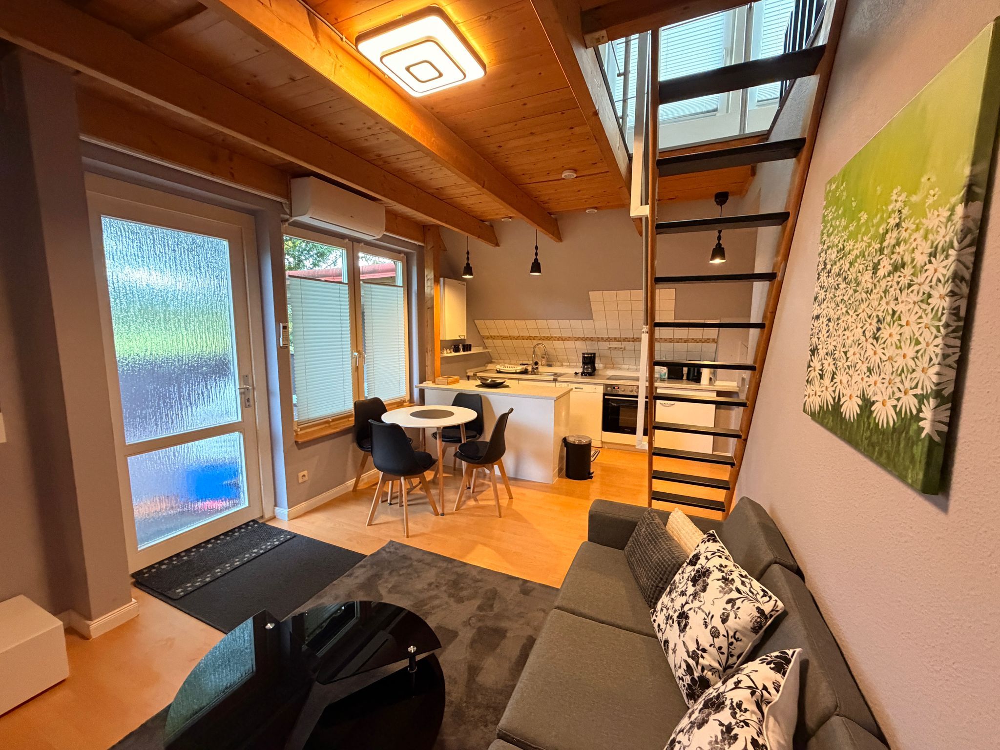 Et moderne interiør med et køkken, spiseplads og et sovehems med udsigt.