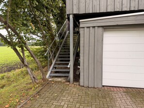 A garage with a metal staircase leading to a vehicle.