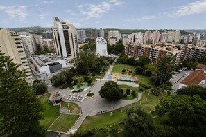 Ein hoch aufragendes Gebäude mit einzigartiger Architektur, umgeben von einem Park mit Spielplätzen und Sitzgelegenheiten.